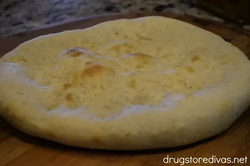 Baked pizza crust on a pizza peel.