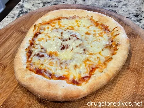 A baked cheese pizza on a pizza peel.