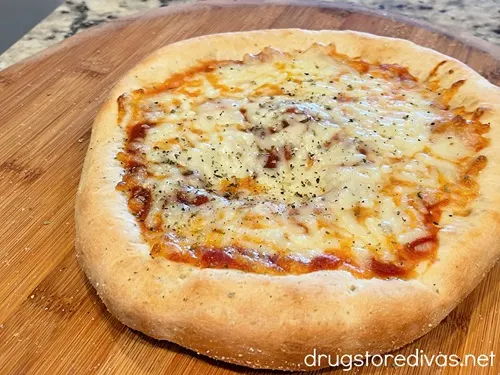 A baked cheese pizza on a pizza peel.