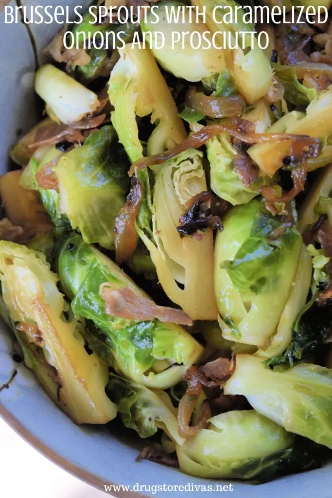 Brussels sprouts, cooked onions, and prosciutto pieces in a blue bowl with the words "Brussels Sprouts With Caramelized Onions And Prosciutto" digitally written on top.
