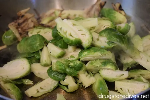 Caramelized onions and quartered Brussels sprouts in a pan.
