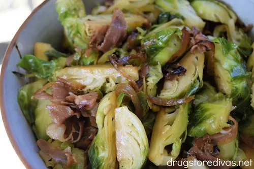 Brussels Sprouts With Caramelized Onions And Prosciutto in a blue bowl.