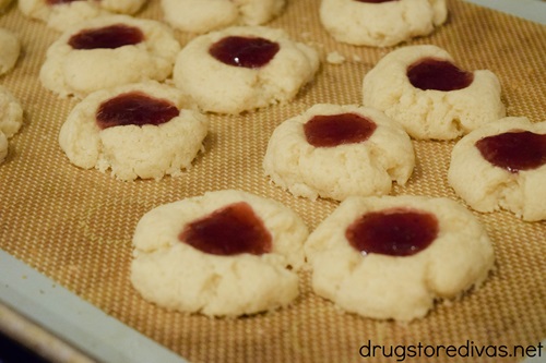 Ten Strawberry Thumbprint Cookies on a silicone baking mat.