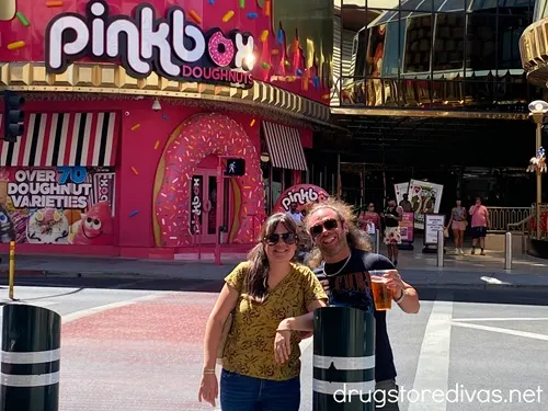 A man and woman standing in front of a Pinkbox Doughnut location in Las Vegas.