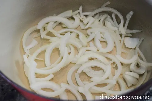 Sliced onions in the bottom of a Dutch oven.