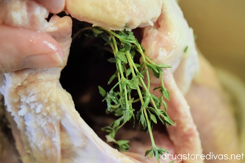 Fresh thyme sprigs in the cavity of a chicken.
