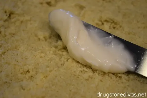 A knife spreading mayonnaise on bread.