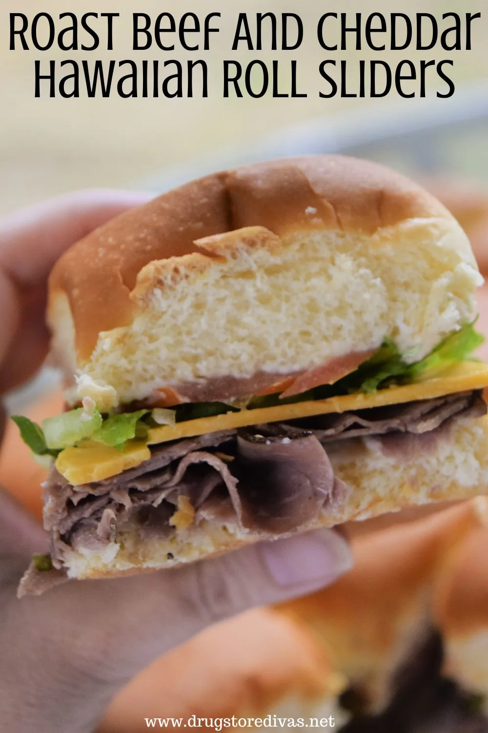A hand holding a roast beef slider with the words 