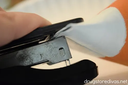 A staple stapling a cardboard tube folded in half.