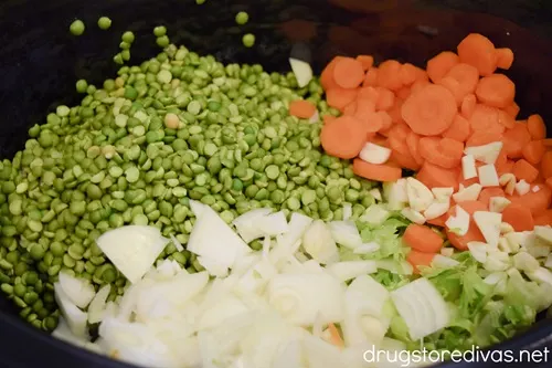 Split peas, sliced carrots, sliced onions, and garlic in a slow cooker.
