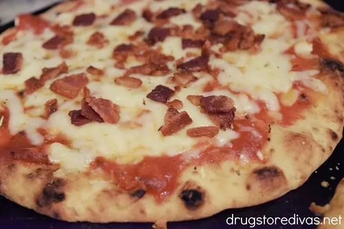 Naan pizza with bacon on top.