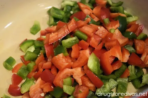 Red and green bell pepper pieces in a Dutch oven.
