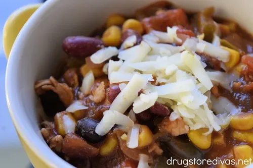 A bowl of Chicken Chili with shredded cheese on top.