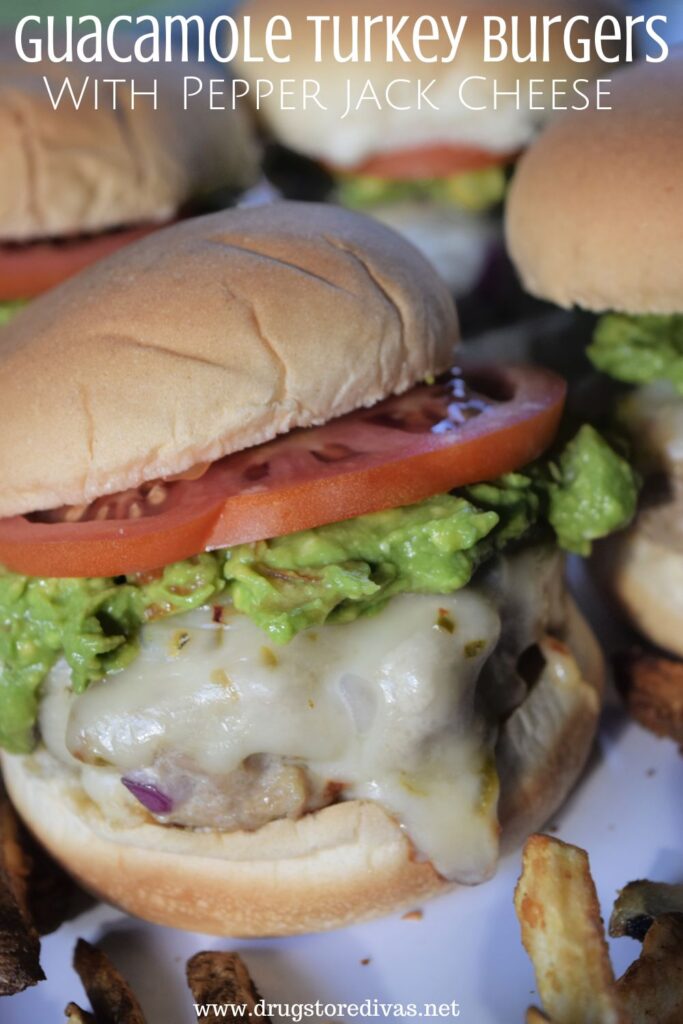 Four Guacamole Burgers with cheese on a tray with fries and the words "Guacamole Turkey Burgers With Pepper Jack Cheese" digitally written above them.
