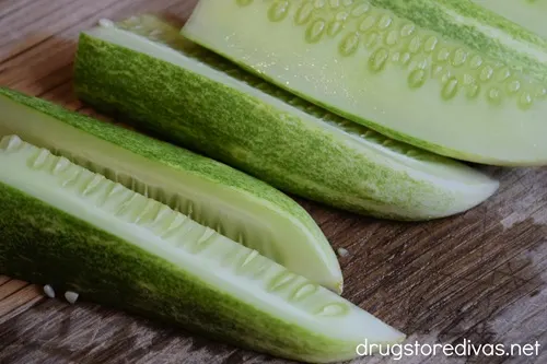 Cucumber spears on a wooden cutting board.