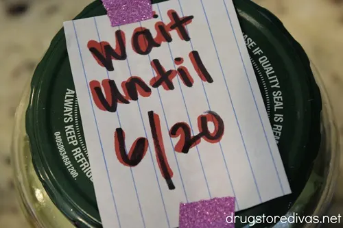 A piece of paper that says "Wait Until 6/20" taped to a pickle jar.