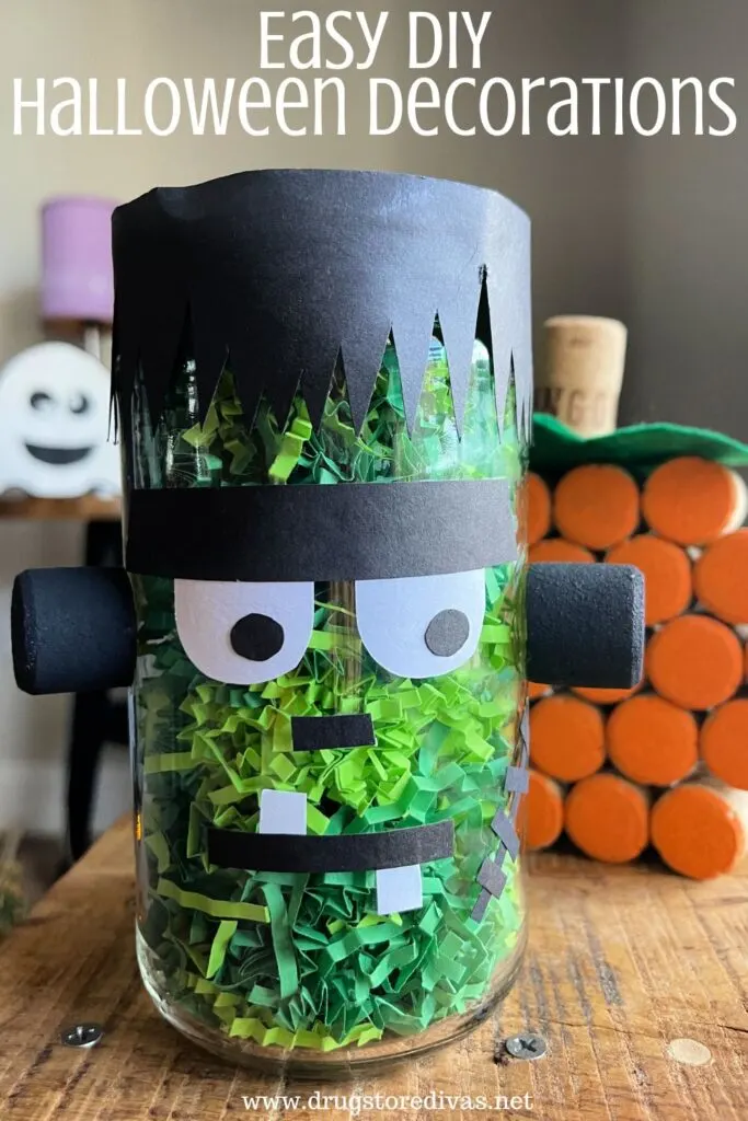 A glass jar made to look like Frankenstein, a wine cork pumpkin, and a small ghost in the background with the words "Easy DIY Halloween Decorations" digitally written on top.