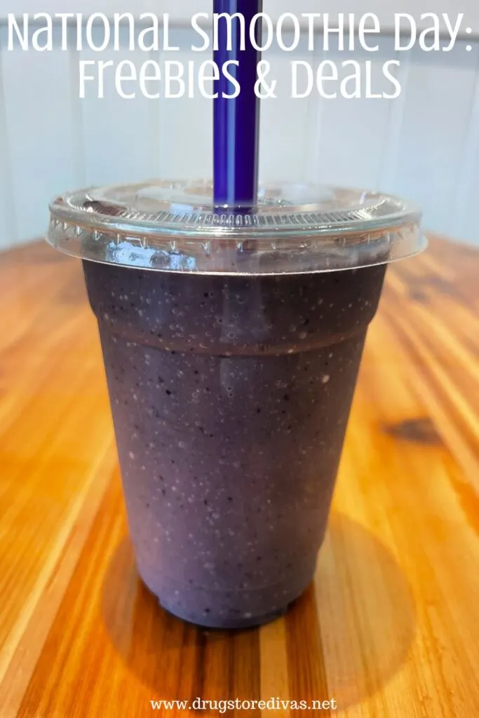A purple smoothie with a purple straw on a table with the words "National Smoothie Day: Freebies & Deals" digitally written on top.
