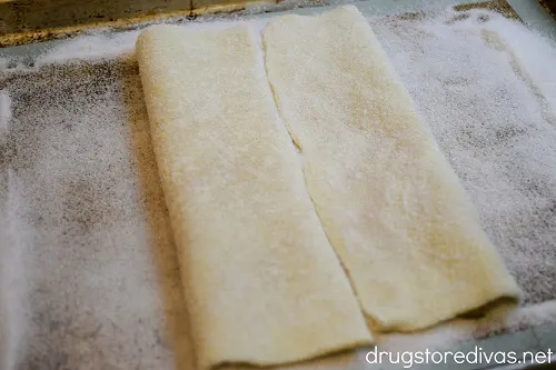 Folded puff pastry on a silicone baking mat.