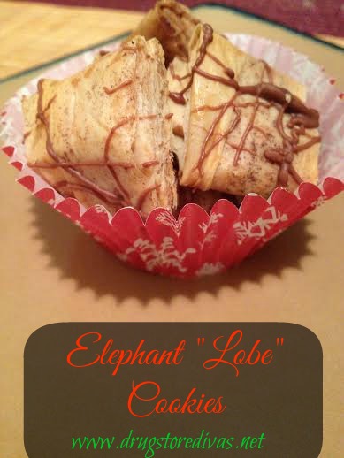 A few chocolate-drizzled mini Elephant Ear cookies in a cupcake wrapper on a plate with the words 