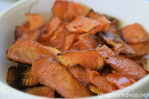Baked carrot chips in a white bowl.