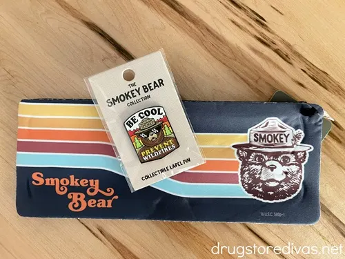 A retro Smokey Bear slap koozie and a pin.