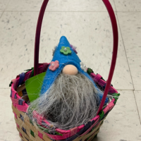 A small Easter basket with a gnome in it and the words 