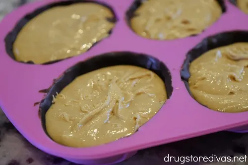 Peanut butter in chocolate-filled cavities of a pink egg mold.