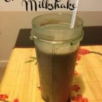 A chocolate milkshake on a table with the words 