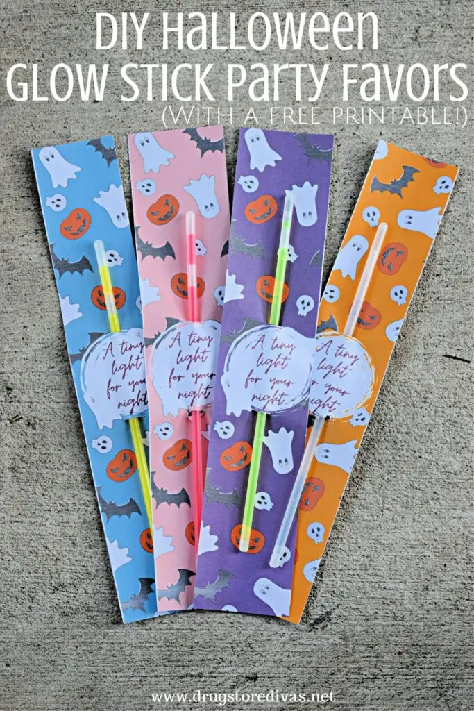 Four glow sticks in a blue, pink, purple, and orange Halloween themed holder, with the words "DIY Halloween Glow Stick Party Favors" digitally written on top.