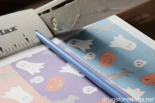 A paper trimmer cutting Halloween themed paper.