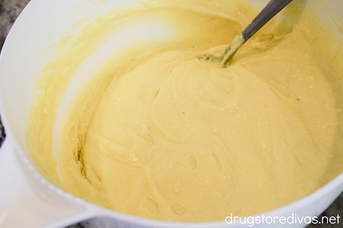 A yellow cake batter and spoon in a white bowl.
