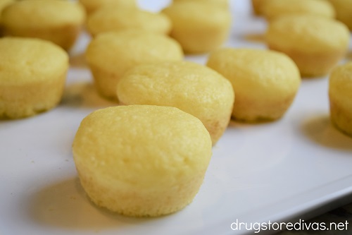 Mini lemon muffins on a white tray.