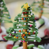 Chocolate Christmas trees on top of holiday cupcakes with the words 