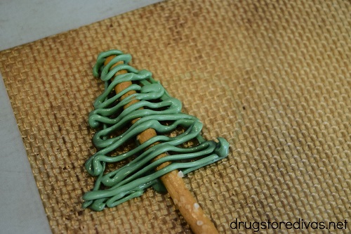 An undecorated Chocolate Christmas Tree Pretzel Stick on a silicone baking mat.