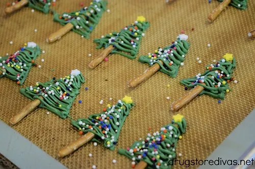 Seven Chocolate Christmas Tree Pretzels on a silicone baking mat.