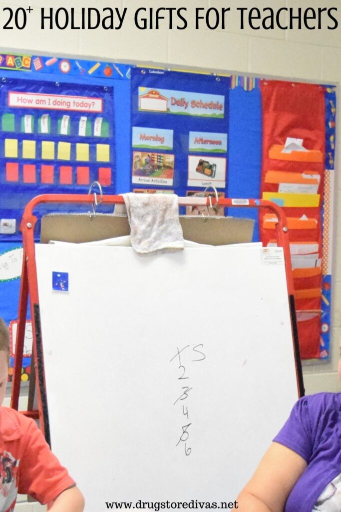 Photo of a dry erase easel in a classroom with the words "20+ Holiday Gifts For Teachers" digitally written on top.