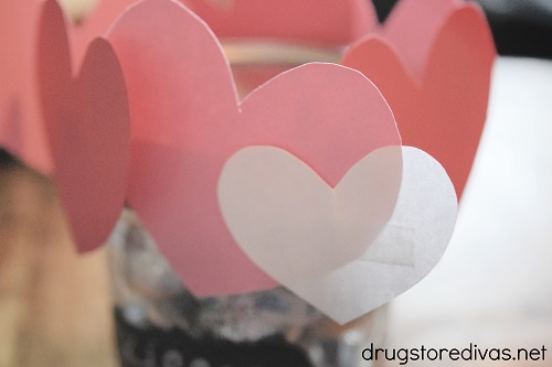 White, pink, and red hearts taped along the top of a mason jar.