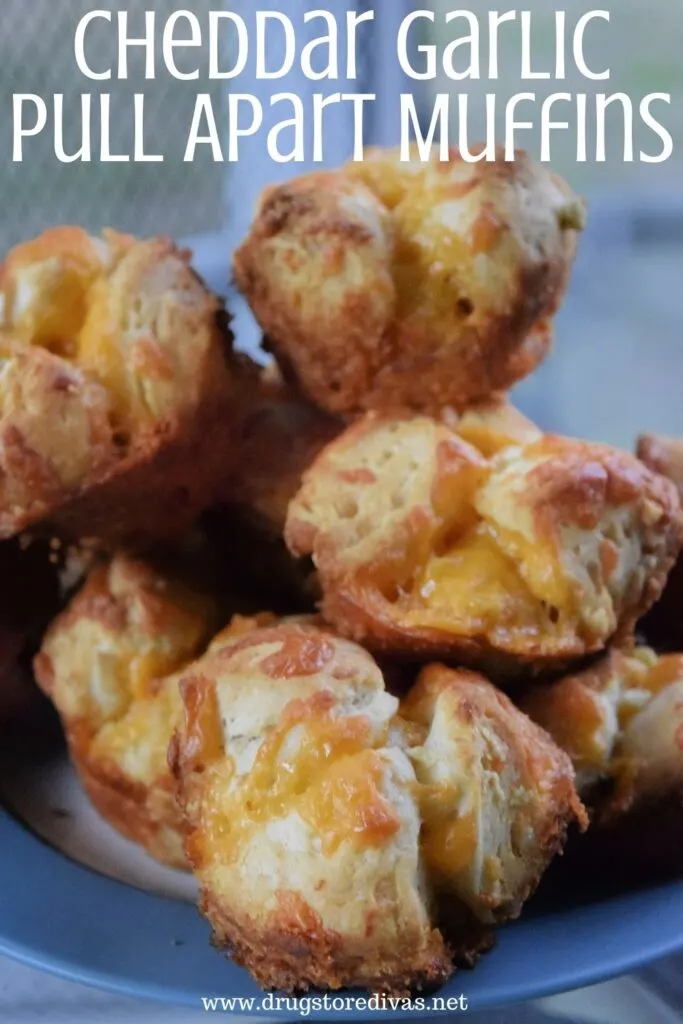 Garlic bread knots on a plate with the words "Cheddar Garlic Pull Apart Muffins" digitally written on top.