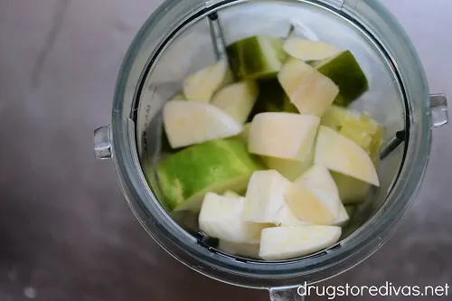 Cubed cucumber and garlic in a blender cup.