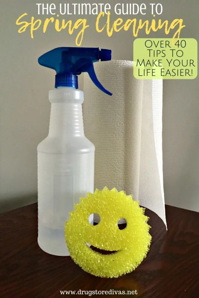 A spray bottle, towels, and a Scrub Daddy on a table with the words "The Ultimate Guide To Spring Cleaning Your Home (over 40 tips to make your life easier)" digitally written on top.