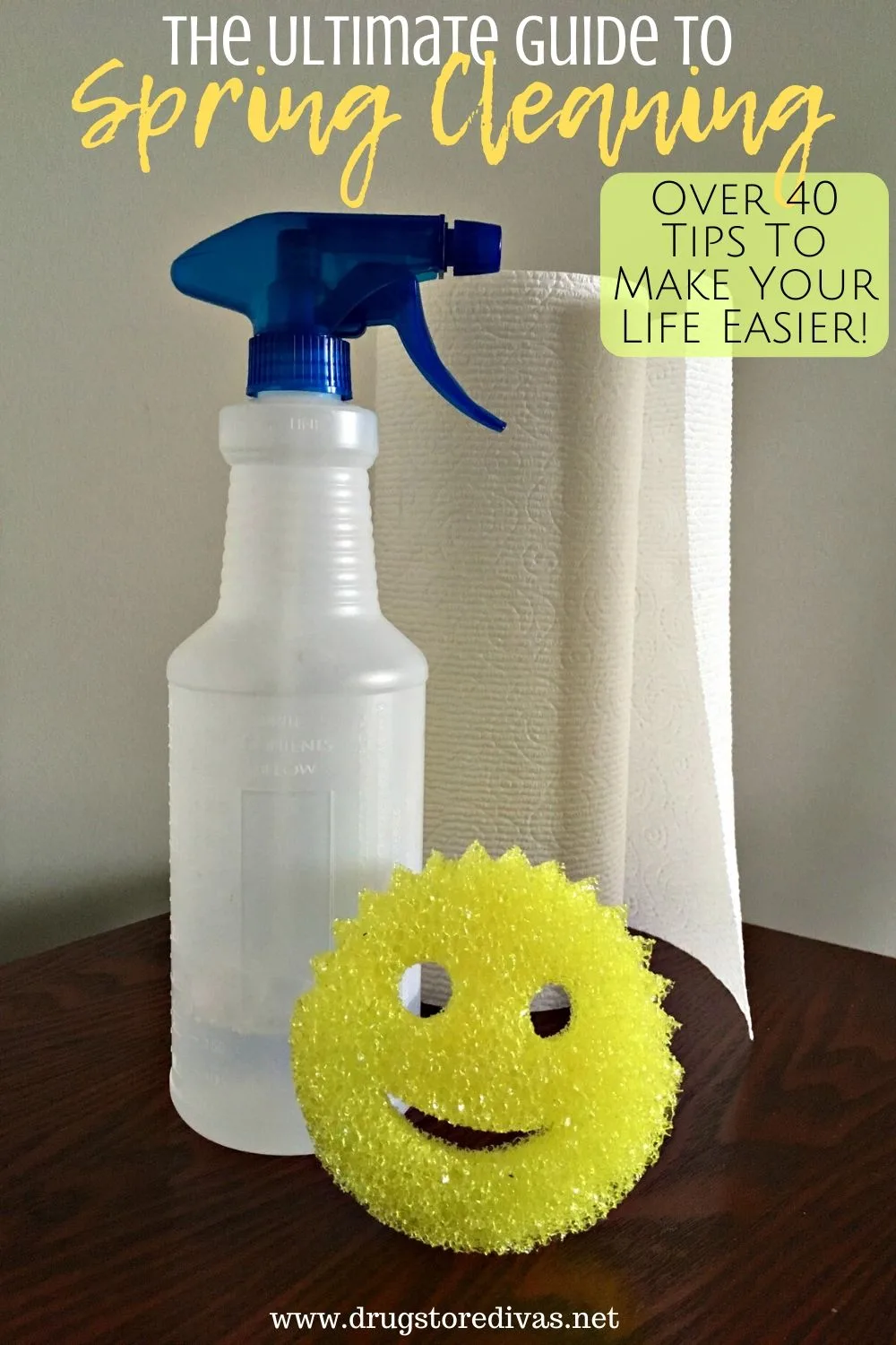 A spray bottle, paper towels, and a Scrub Daddy on a table with the words "The Ultimate Guide To Spring Cleaning" digitally written on top.