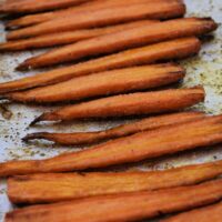 Cooked carrots on a sheet pan with the words 