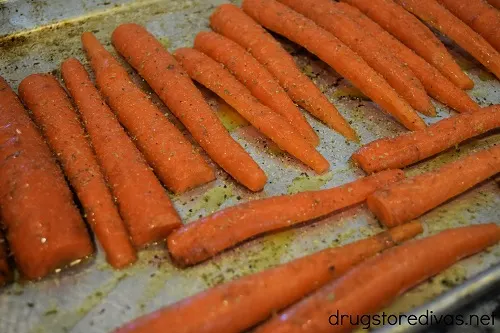 Carrots on a sheet pan, with olive oil and seasoning on top.
