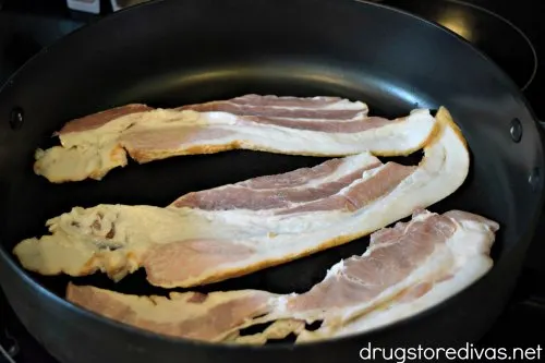 Three pieces of bacon in a pan.