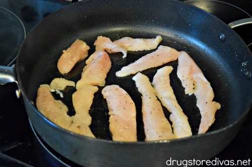 Chicken breast tenderloins in a pan.