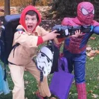 Two children dressed up for Halloween, one as a ghostbuster and one as Spiderman, with the words 