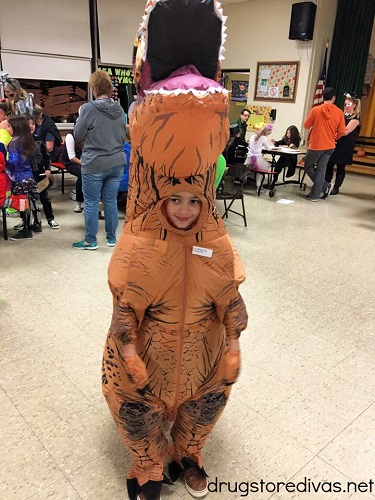 A boy in a T-rex Halloween costume.