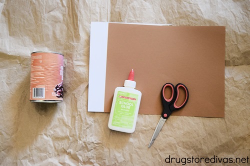 A tin can, white and brown card stock, glue, and scissors.