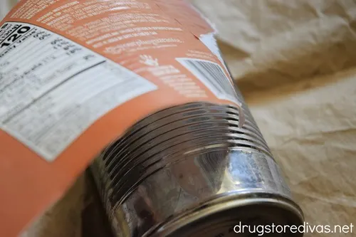 A label being pulled off a can.